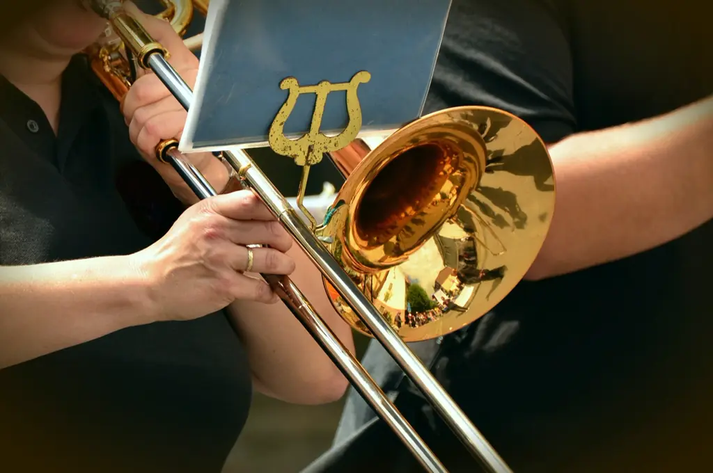 Posaune und Notenhalter in den Händen einer Musikerin bei der Probe
