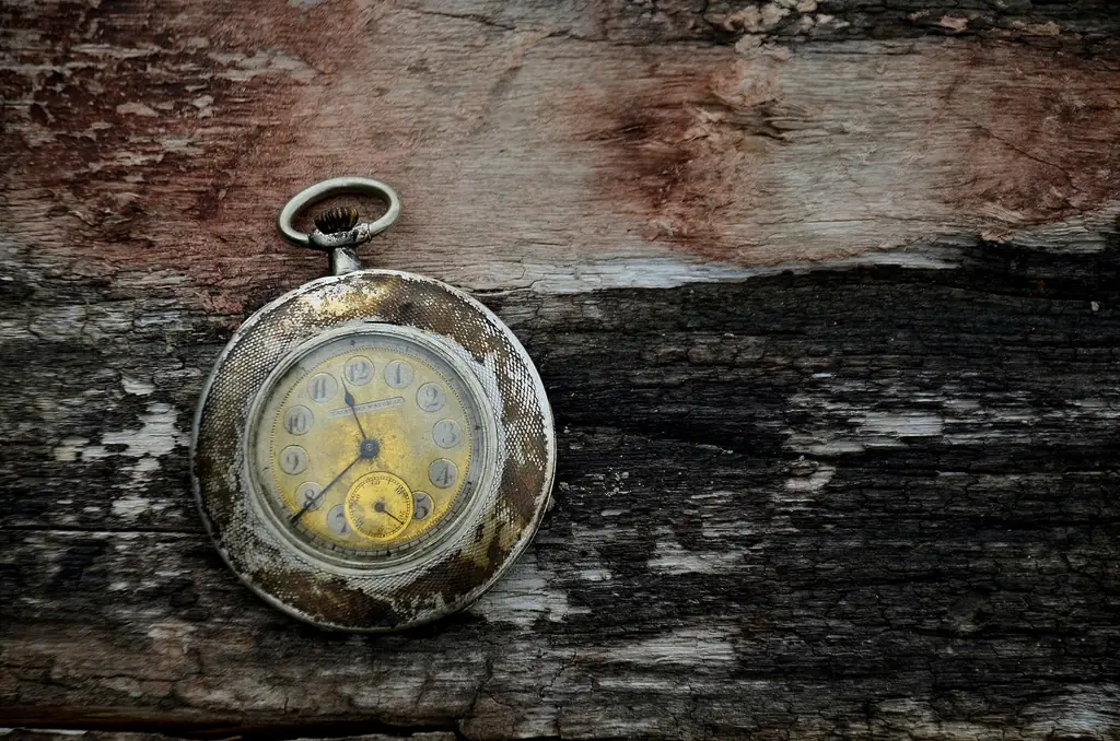 Alte silberne Taschenuhr auf einem verwitterten Holzbrett