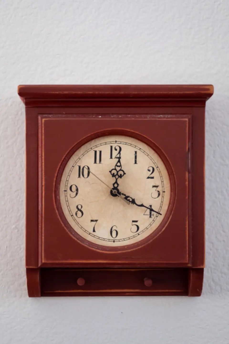 Rote Wanduhr aus Holz mit hellem Zifferblatt